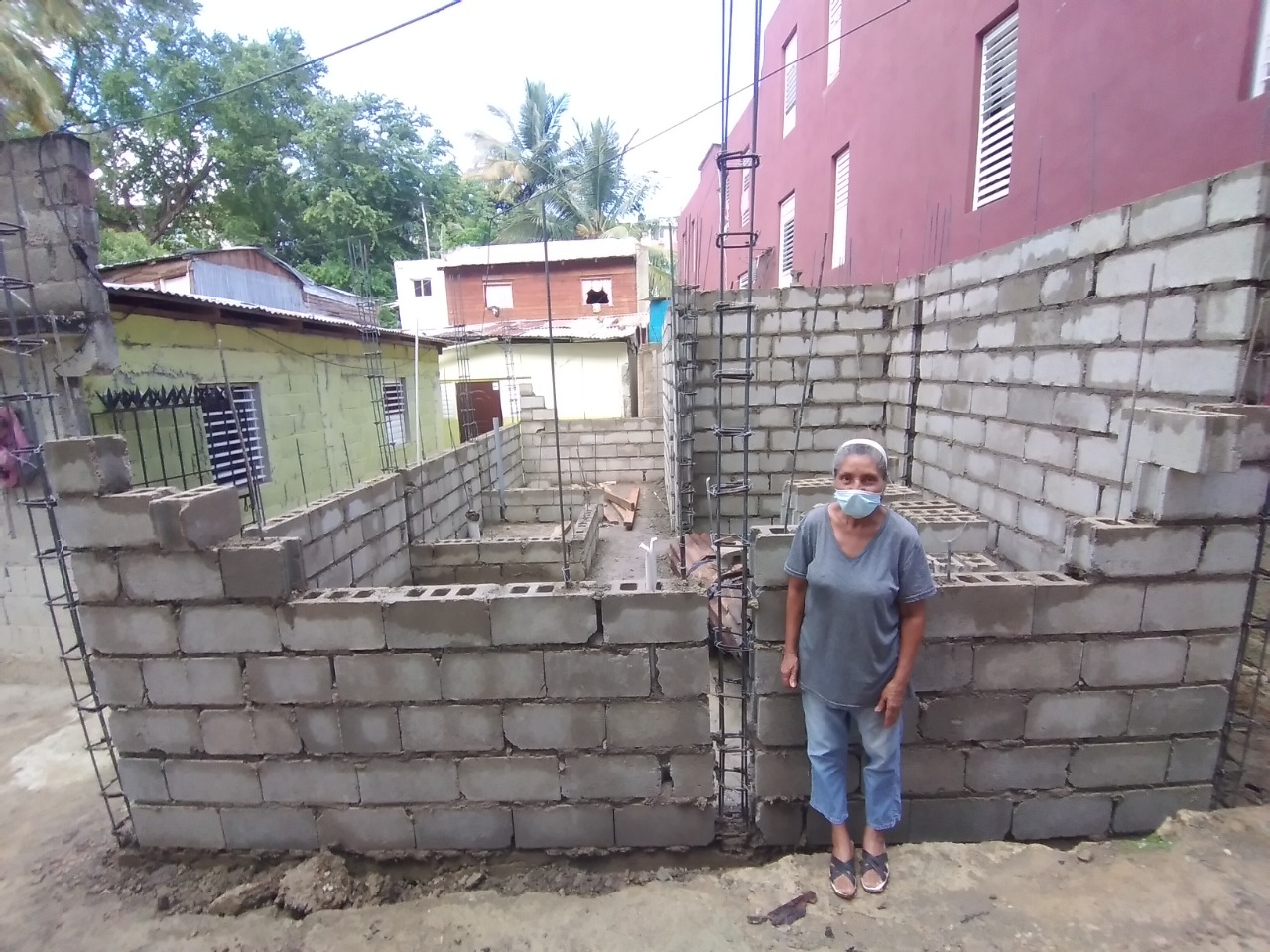 Señora junto a casa en construcción